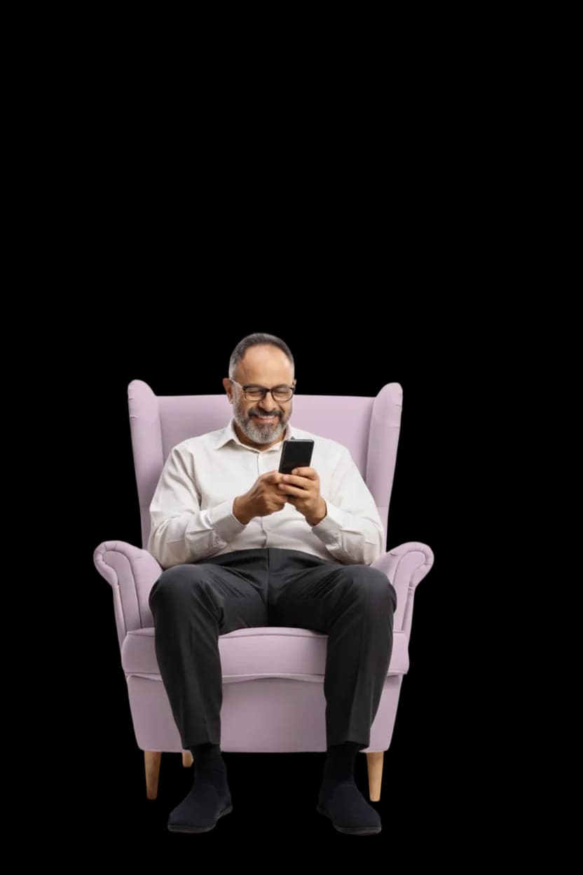 أب مبتسم في كرسيه يستعمل هاتفه